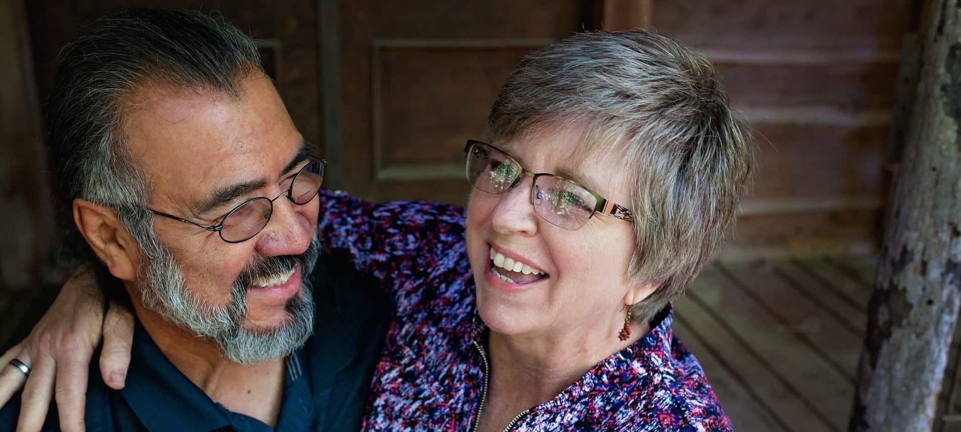 Man and woman, owners of Lone Cedar Cabins, embracing and smiling