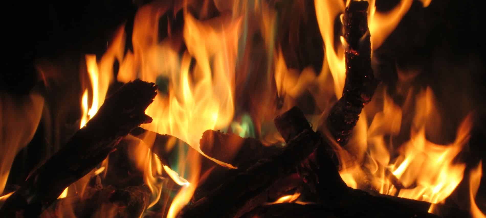 Close up view of an outdoor campfire with warm yellow and orange flames